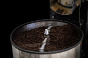 新鲜的咖啡豆和烤过的纺纱盖上专业机器的特写照片和黑色背景摄影图片